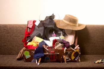 Charges girl to travel. The old suitcase piled disorderly everything that can be useful for rest and recreation