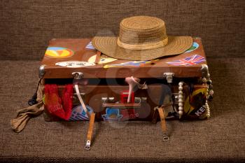 Charges girl to travel. The old suitcase piled disorderly everything that can be useful for rest and recreation