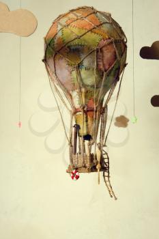 Strange steampunk balloon which flies between clouds and aims for the stars. On light background