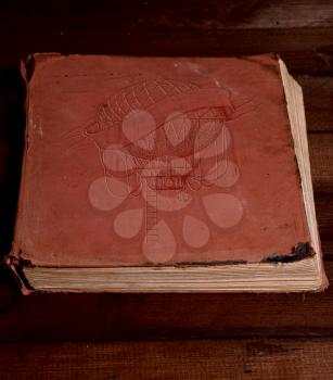 Old shabby closed book with embossed balloon on the cover