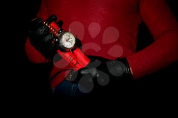 Terrorist in red sweater and gloves holds in hands time bomb