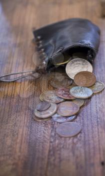 purse with old coins were scattered on oak wooden board