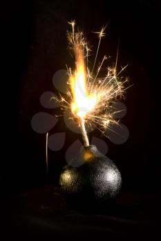 An old round bomb with a firing wick on a black background