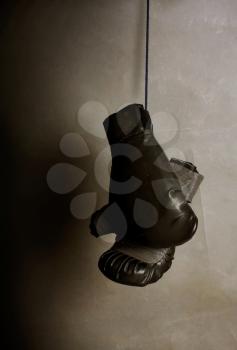 old gloves for boxing hang on a dark gray background