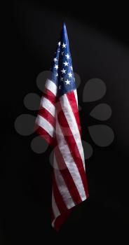 Hanging in neat folds on a dark background starry striped US Flag