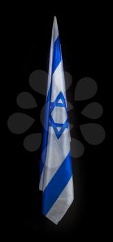 Hanging down smooth pleats against a dark background Flag of Israel