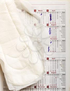Hygienic liner lying over the calendar with marked days when menstrual cycles