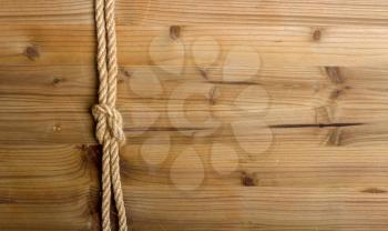 sea knot of rough rope on a simple wooden light brown background