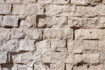 An old wall of white cracked brick with fallen off plaster