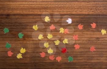 small paper maple leaves on an old wooden board