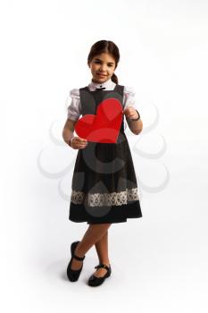Little girl in a simple modest dress smiling giving a big red cardboard heart