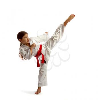 The little girl in a white kimono with a red belt competition causes a high kick