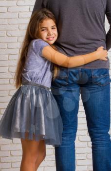little girl loving hugging her dad's waist