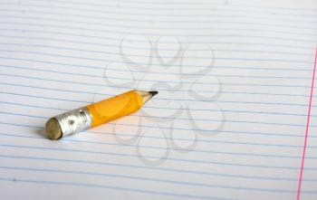 a small stub of a pencil lying on a school notebook in line