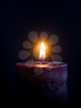 Dark Wax candle with a burning light on a dark background