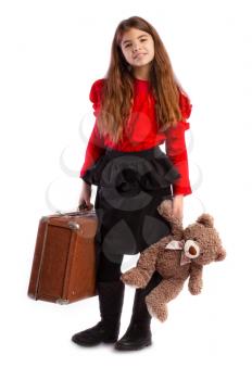 little girl packed her vintage retro suitcase and waits with her favorite teddy bear