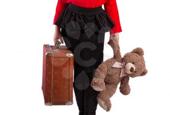 little girl packed her vintage retro suitcase and waits with her favorite teddy bear