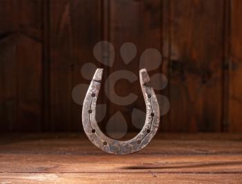 old classic horseshoe symbol of good luck over dark wooden background