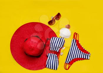 top view set of women's beach accessories and things for relaxation on a bright yellow background