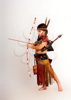 little indian girl in traditional dress shoots a bow