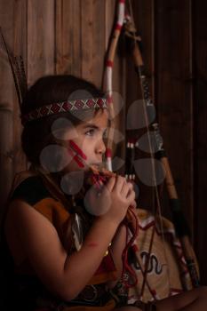 little indian girl in traditional dress plays the flute
