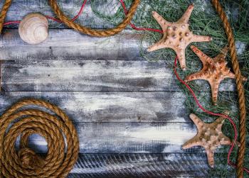 old painted wooden boards over which lies a fishing net with starfish. With place for your text.