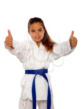 little karate girl in a white kimono and a blue belt shows a sign perfectly holding thumb up