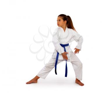 a karate girl in a white kimono and a blue belt performs an exercise from kata in training