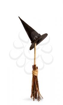 classic witch pointed black wide-brimmed hat hanging on a wooden broomstick for flying