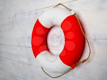 classic life buoy hanging on a rough light wooden wall