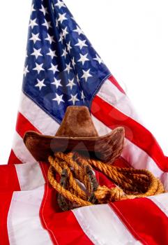 cowboy hat, lasso and horseshoe lying on the usa flag isolated on white background