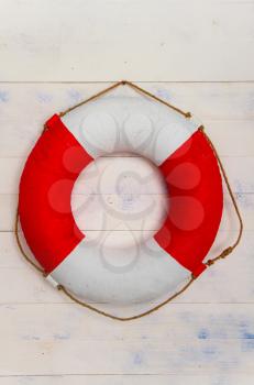 classic life buoy hanging on a rough light wooden wall