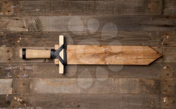 children s homemade wooden sword lying on an old wooden background