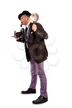 Comic character old photojournalist with camera and flash in a hat and a fashionable suit of those times at a photo shoot