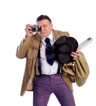 adult news photographer in a costume of the last century fashion and a wide-brimmed hat with an old camera diligently takes a photo
