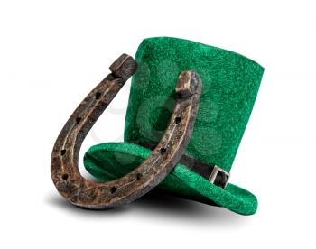 A classic green hat is a fairytale leprechaun hat and a metal horseshoe that brings good luck. Symbols of St. Patrick's Day. Isolated on a white background.