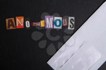 The word anonymous cut out in separate letters from different newspapers on a dark background