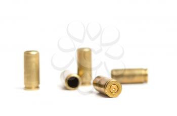 several used brass shells from a nine mm pistol on a white background