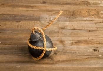 classic round black antique bomb with a long non-burning rope wick on a rough wooden background