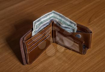 old leather wallet with small dollar bills