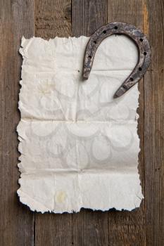 vintage torn blank parchment scroll and steel horseshoe