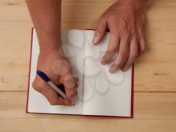 Male hands of the author who puts his autograph on a blank page in a new book