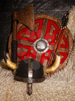 steel ax horned helmet and wooden viking shield with pattern