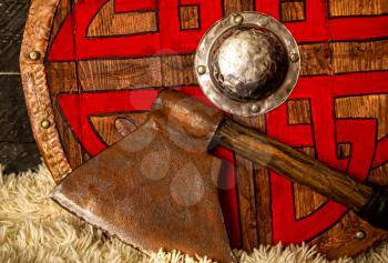steel ax and wooden viking shield with pattern close up