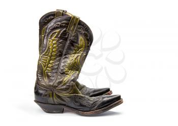 Shabby old ornate classic cowboy boots on wite background