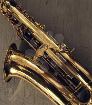 graceful classical musical instrument bronze saxophone on old wooden background