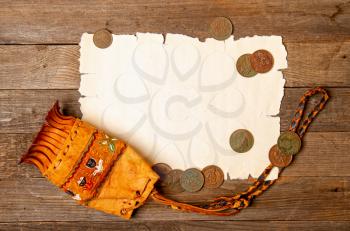blank sheet of yellowed old papyrus blank for treasure map, antique wallet with several copper coins