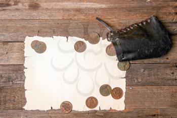 blank sheet of yellowed old papyrus blank for treasure map, antique wallet with several copper coins