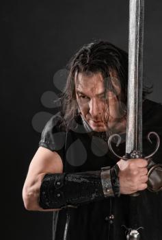 formidable knight holding a sword on a dark background