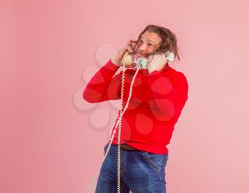 Adult male call center worker in casual clothes answers phone calls very emotionally
